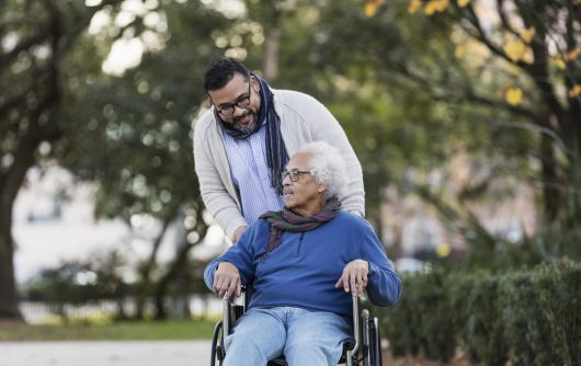 Senior Hispanic man in wheelchair, with adult son