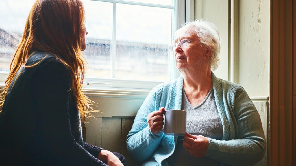 Older woman talking with her young daughter at home