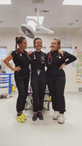 Trois infirmières souriant et posant pour une photo dans une chambre d'hôpital