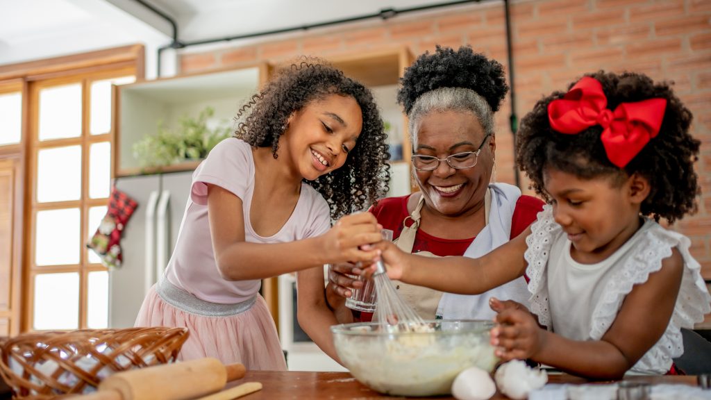 Grandma and granddaughters making Christmas cookies