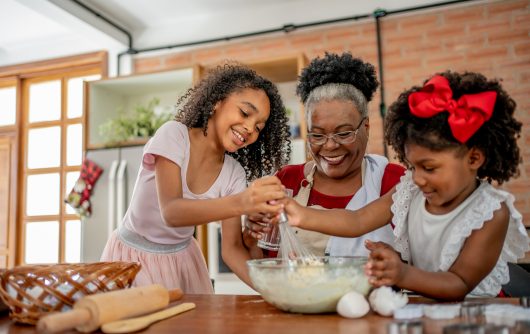 Grandma and granddaughters making Christmas cookies