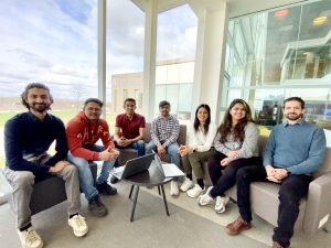 A group of students seven sitting and posing for a group photo