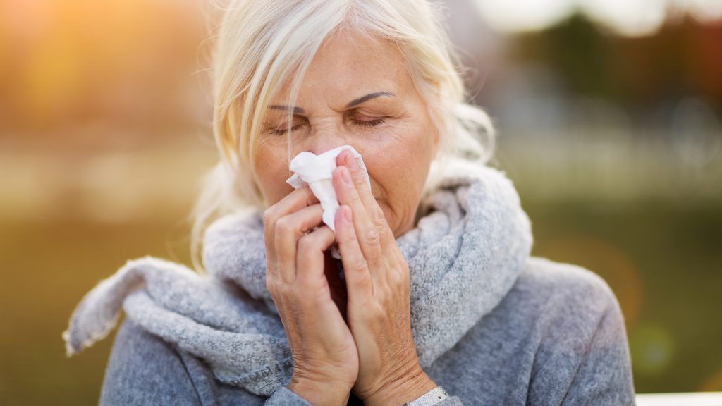 Sick woman blowing her nose