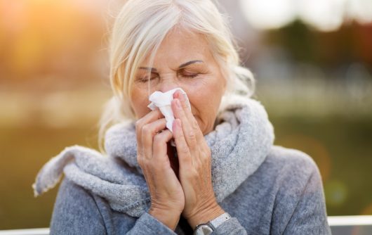 Sick woman blowing her nose