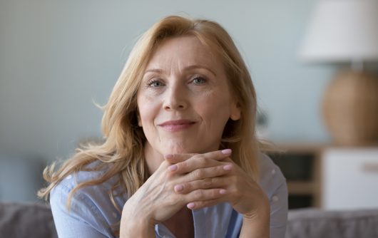 middle-aged woman resting on sofa look at camera