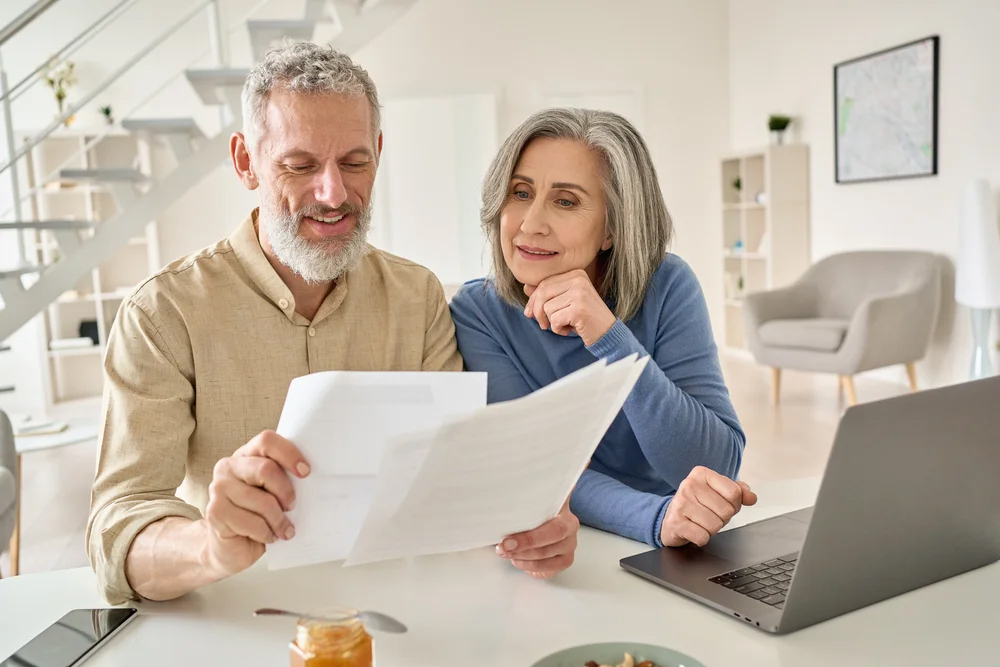 Senior couple sitting together and looking at documents