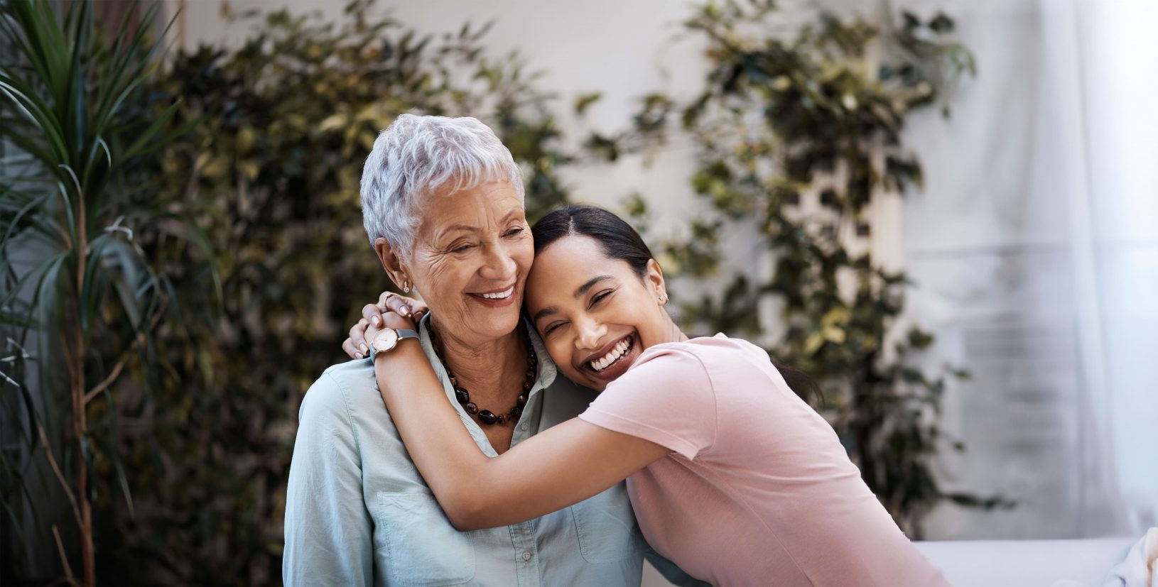 A young woman hugging a smiling elderly woman