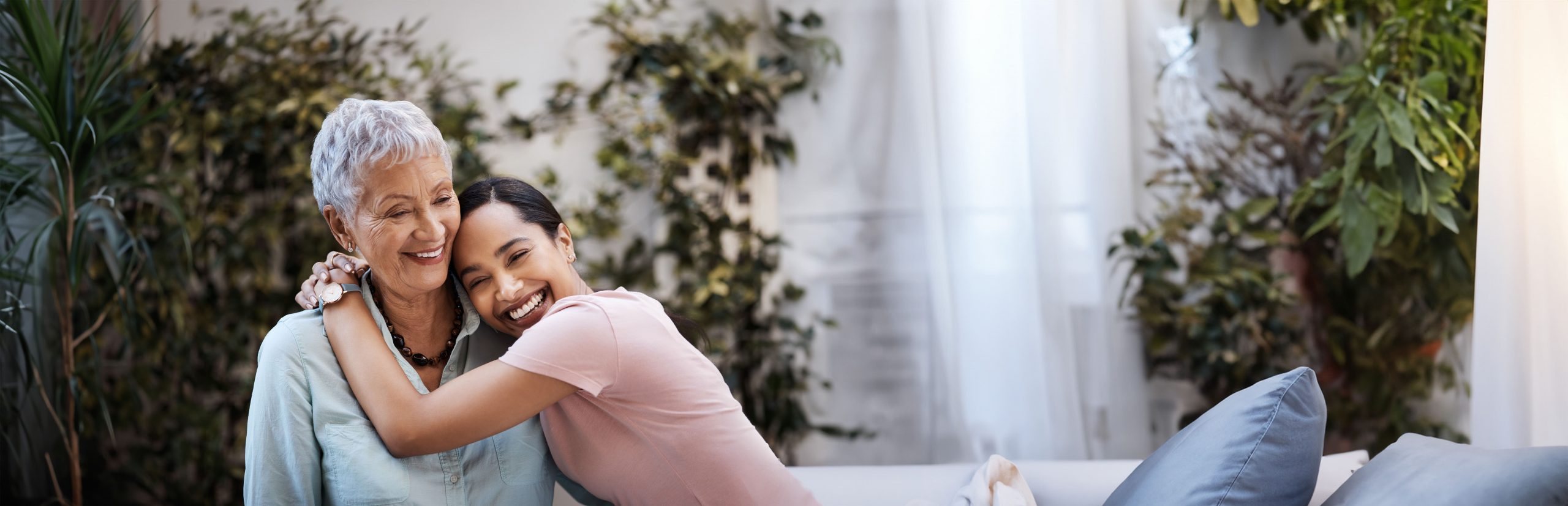 A young woman hugging a smiling elderly woman